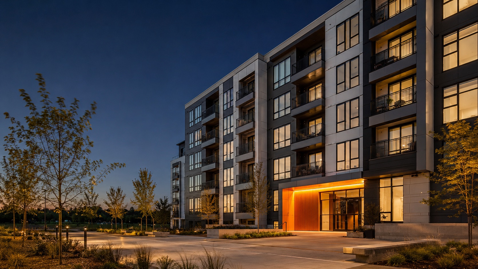 Factory-built multifamily apartment building at dusk, warm entry light (illustrative concept)